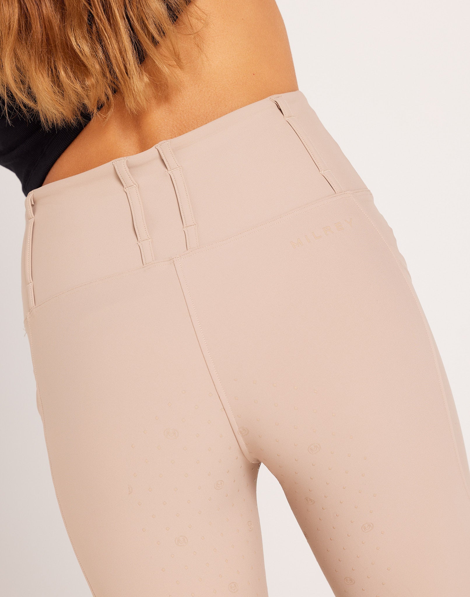 Women's high-rise knee grip beige equestrian breeches for horse riding, designed with performance stretch fabric, supportive waistband, flattering seam lines, and functional pockets. Versatile riding pants for schooling, casual rides, barn days, and everyday equestrian wear.