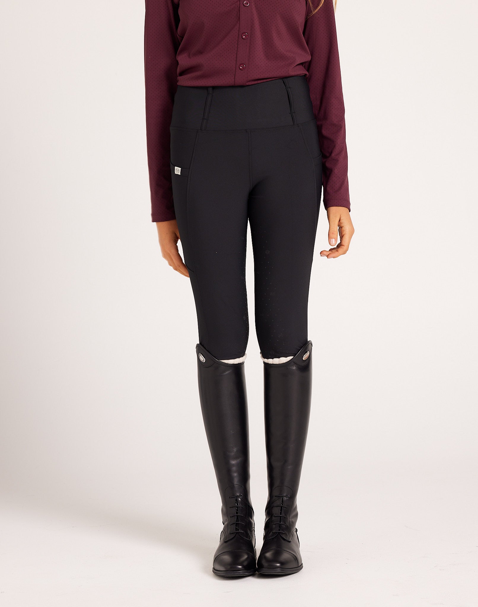 Women's high-rise knee grip black equestrian breeches for horse riding, designed with performance stretch fabric, supportive waistband, flattering seam lines, and functional pockets. Versatile riding pants for schooling, casual rides, barn days, and everyday equestrian wear.
