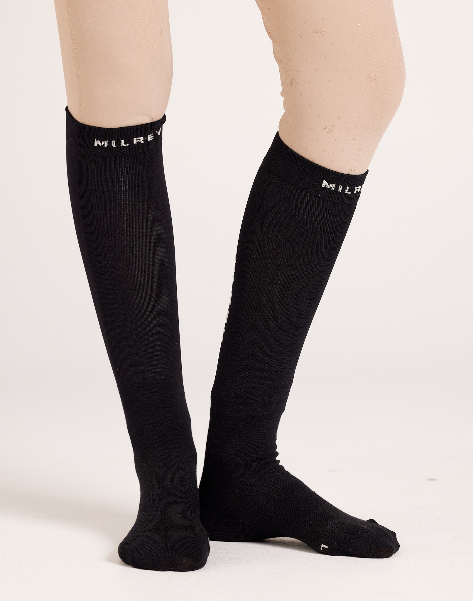 Women's knee-high technical riding socks in breathable cotton blend, featuring compression support and moisture-wicking properties for equestrian activities.